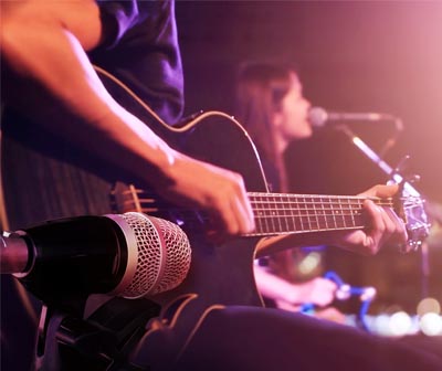 musicien lors d'un concert en live jouant de la guitare acoustique